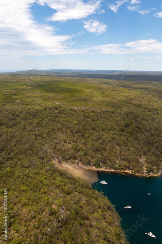 Boats anchored at a remote secluded beach in Australian bushland aerial.