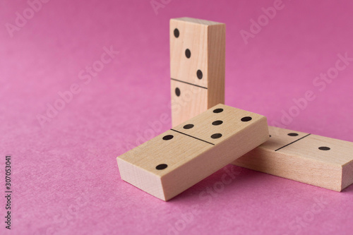 Playing dominoes on a purple background. Leisure games concept. Domino effect.