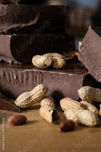 Closeup of Chocolate Hunks, Peanuts, and Pretzels on a Rustic Wooden Table Top in Preparation for Baking