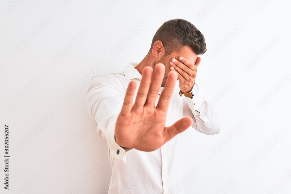 Young handsome business man wearing elegant shirt over isolated background covering eyes with hands and doing stop gesture with sad and fear expression. Embarrassed and negative concept. Young handsome business man wearing elegant shirt over isolated background covering eyes with hands and doing stop gesture with sad and fear expression. Embarrassed and negative concept.