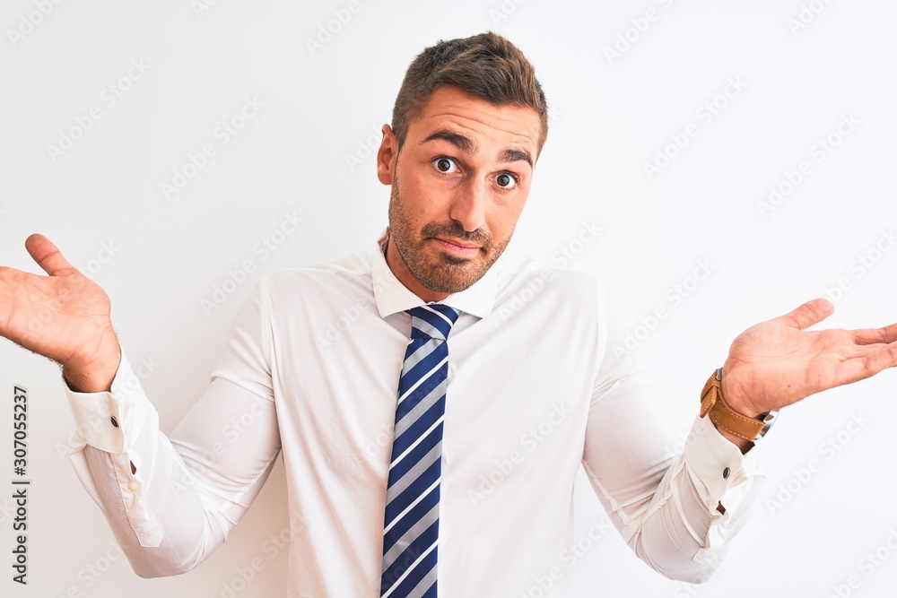 Young handsome elegant business man over isolated background clueless and confused expression with arms and hands raised. Doubt concept. Young handsome elegant business man over isolated background clueless and confused expression with arms and hands raised. Doubt concept.