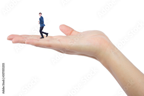 Fotografia Gigantic woman holding a tiny little businessman as a metaphor for loss of self-confidence