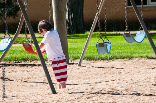 Cute little boy ready to saddle up on the swing