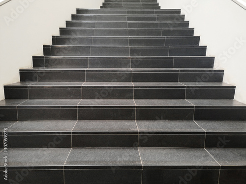 Staircase with black marble stone stairs viewed in perspective. Abstract modern architecture or interior photo in minimalism style.