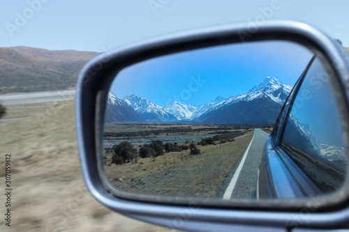 Looking in the side mirror of a car leaving the mountains behind.