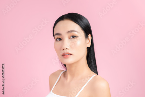 Portrait of young Asian woman with perfect skin on pink background. Concept of natural cosmetics and skincare.