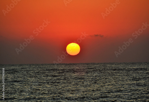 Fototapeta Naklejka Na Ścianę i Meble -  the sun like a ball rising from the sea
