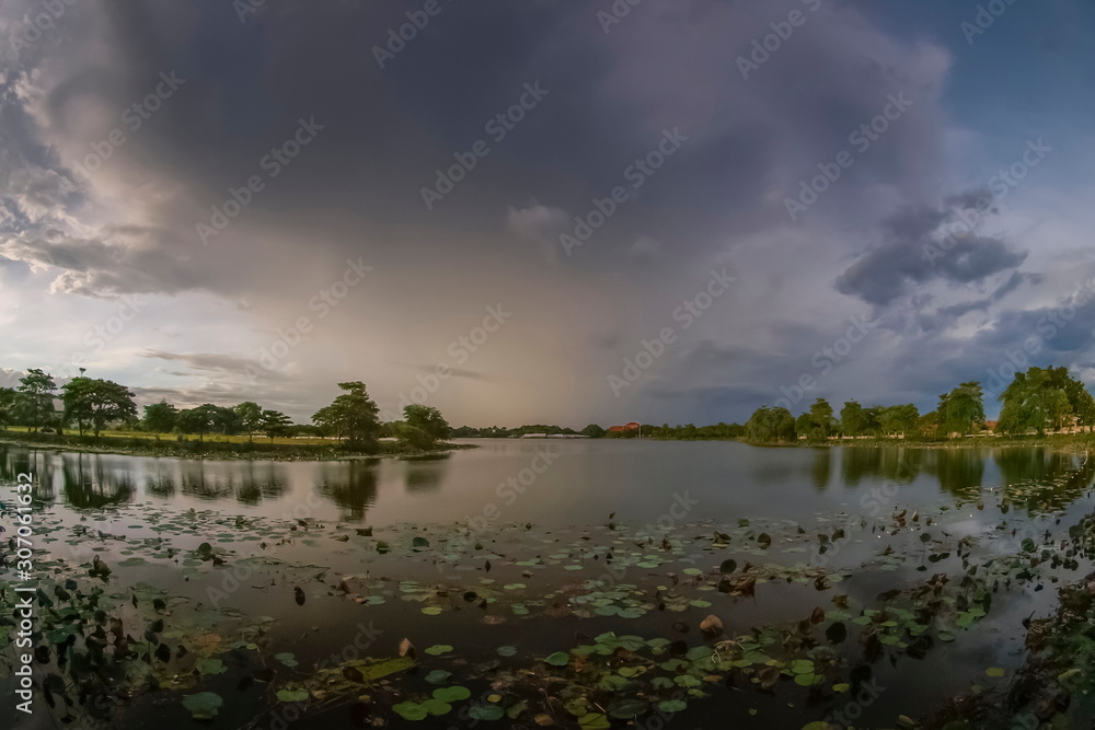 Lake view evening of dark clouds moving in heavy raining above lotus lake, sunset with rain storm above Krajub reservoir, Ban Pong, Ratchaburi, Thailand.