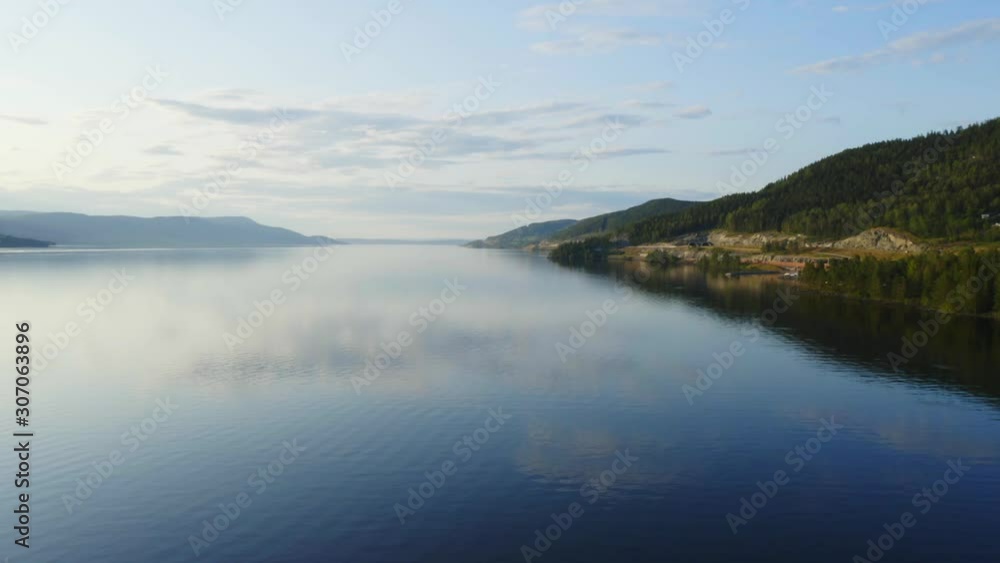 Aerial over quiet lake during golden hour. The warm blue sky is reflecting in the water Aerial over quiet lake during golden hour. The warm blue sky is reflecting in the water