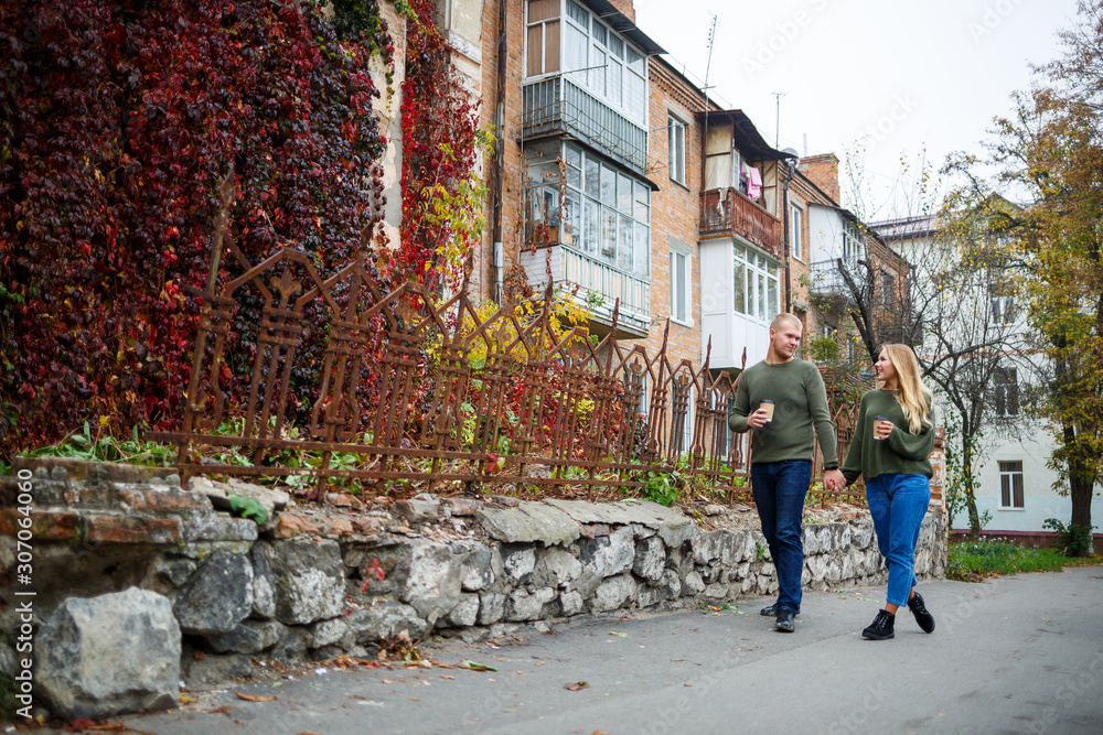 Obraz premium Beautiful couple walking down the street in sweaters and jeans
