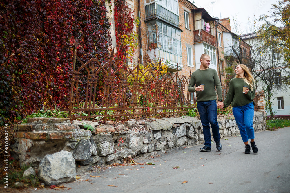 Beautiful couple walking down the street in sweaters and jeans