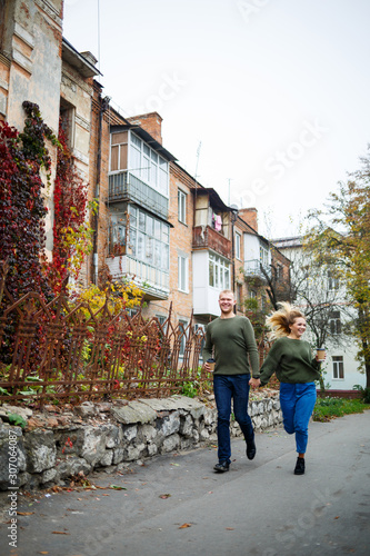 Beautiful couple walking down the street in sweaters and jeans © Дмитрий Ткачук