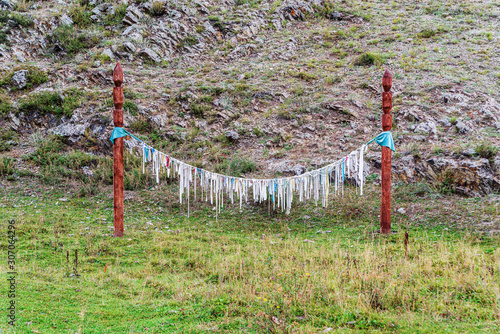 Pillars with ritual ribbons Kiyir. Pagan place of worship in the Altai Mountains photo