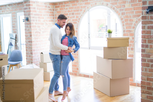 Young beautiful couple dancing  at new home around cardboard boxes © Krakenimages.com