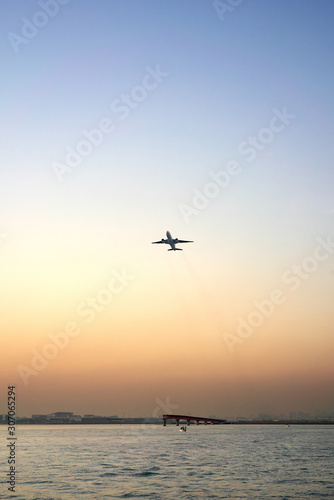 Tokyo,Japan-December 1, 2019: An airplane taking off from runway A of Tokyo Haneda international airport runway A viewed from a boat crusing on Tokyo bay at sunset