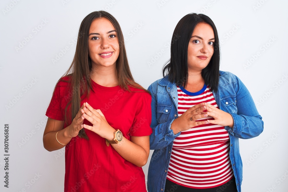 Young beautiful women wearing casual clothes standing over isolated white background Hands together and fingers crossed smiling relaxed and cheerful. Success and optimistic