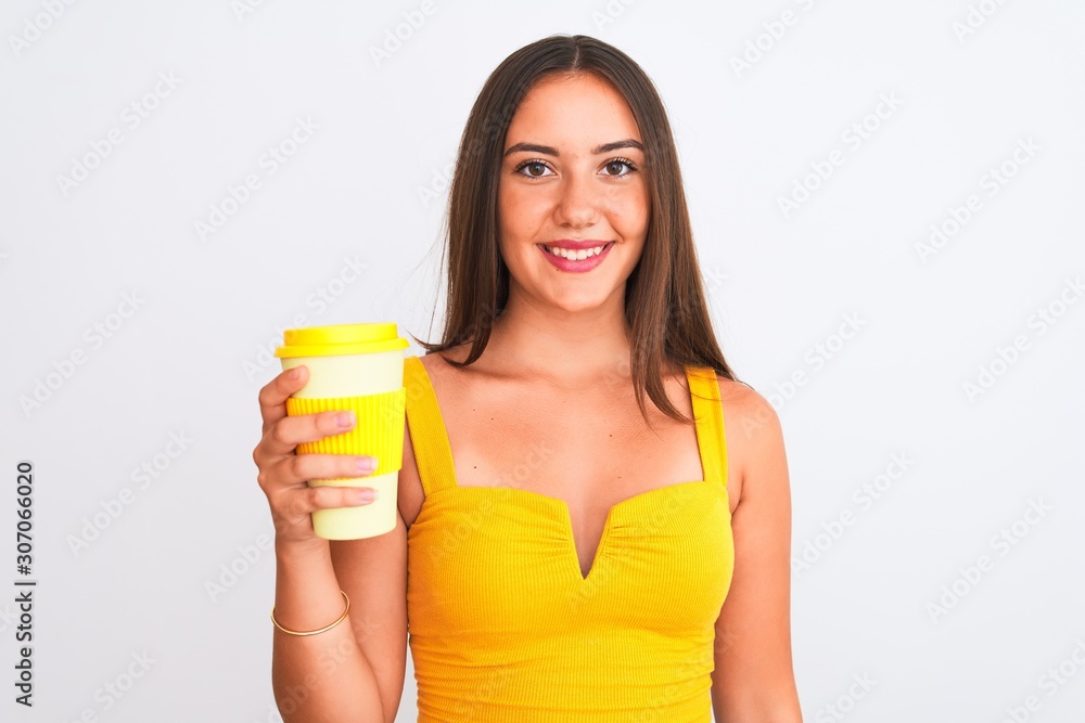 Young beautiful girl drinking paper glass of take away coffee over isolated white background with a happy face standing and smiling with a confident smile showing teeth Young beautiful girl drinking paper glass of take away coffee over isolated white background with a happy face standing and smiling with a confident smile showing teeth