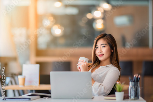 businesswoman having tea or coffee in home office