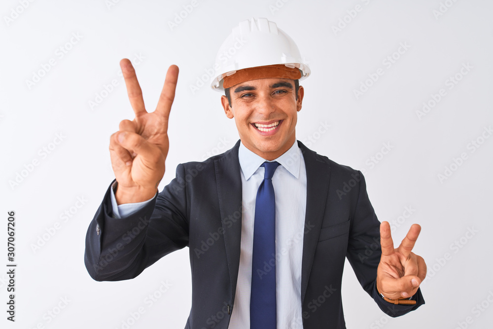 Young handsome architect man wearing suit and helmet over isolated white background smiling looking to the camera showing fingers doing victory sign. Number two. Young handsome architect man wearing suit and helmet over isolated white background smiling looking to the camera showing fingers doing victory sign. Number two.
