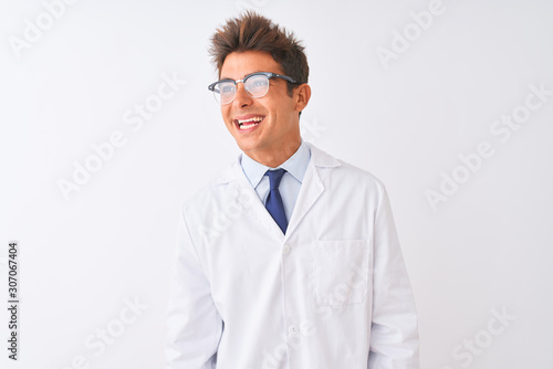 Young handsome sciencist man wearing glasses and coat over isolated white background looking away to side with smile on face, natural expression. Laughing confident.