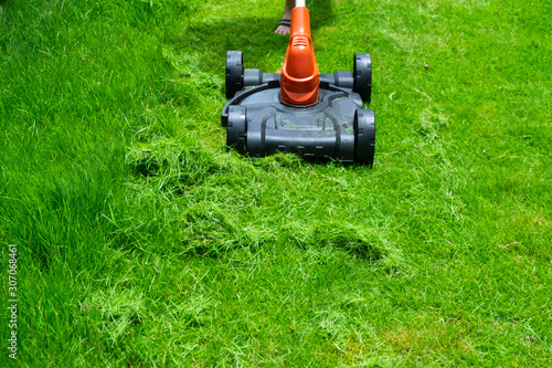 Lawn mower electric mower mowing hight grass in field, yard