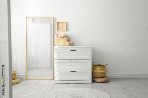 Modern room interior with white chest of drawers