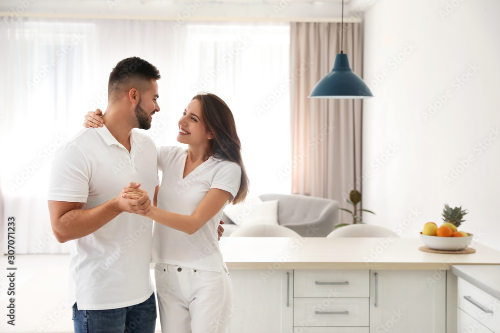 Lovely young couple dancing in kitchen at home Lovely young couple dancing in kitchen at home