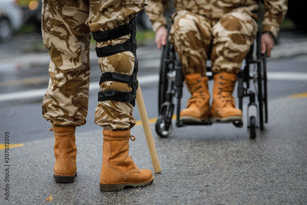 Details with a Romanian army veteran soldier, injured and disabled, sitting in a wheelchair dressed in his military desert camouflage uniform. Details with a Romanian army veteran soldier, injured and disabled, sitting in a wheelchair dressed in his military desert camouflage uniform.