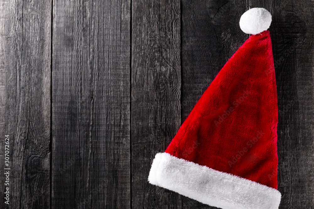 Santa Claus hat on wooden rustic background Santa Claus hat on wooden rustic background