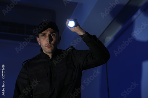 Male security guard with flashlight in dark room © New Africa