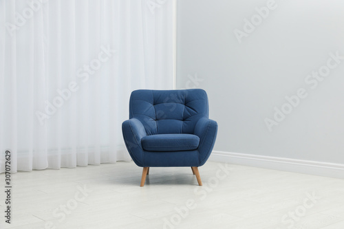 Comfortable armchair near window indoors. Stylish interior element