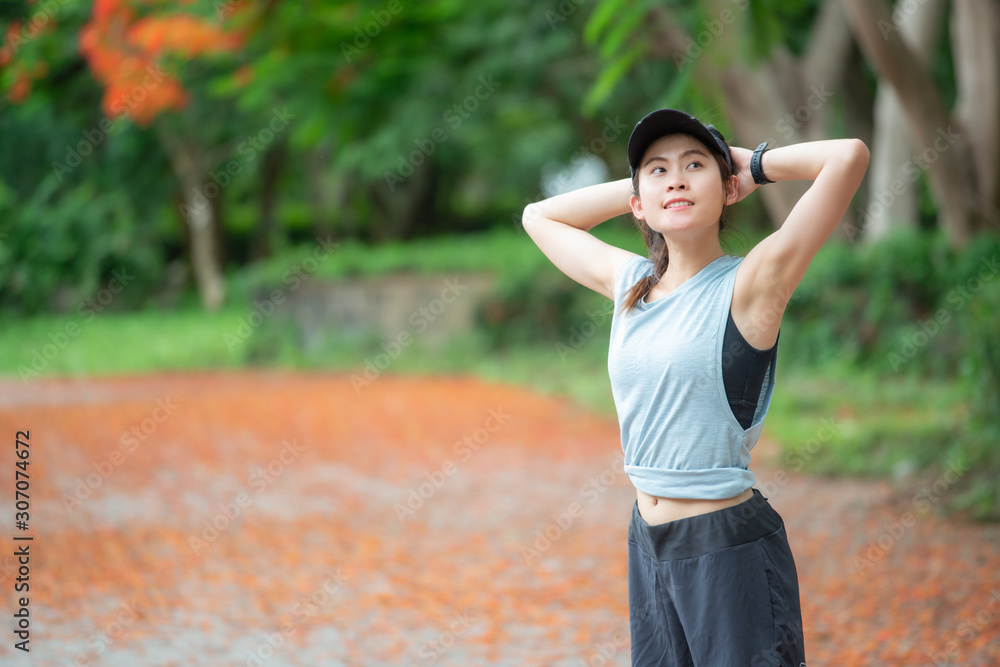 Portrait of runner woman doing stretching and warming up her body before running in the park. The benifit of stretching can increasing flexibility performance and reduce risk of injury. Portrait of runner woman doing stretching and warming up her body before running in the park. The benifit of stretching can increasing flexibility performance and reduce risk of injury.