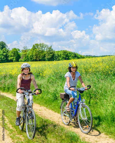 Zwei Frauen mit dem Fahrrad unterwegs auf dem Land