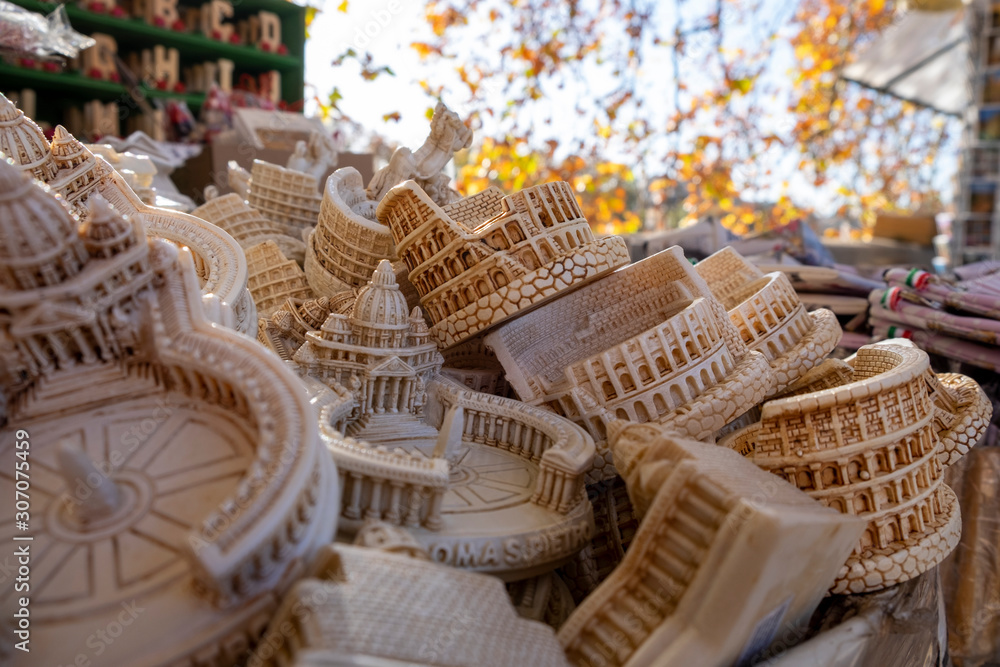 Obraz premium Coliseum and Vatican scaled handmade souvenirs for tourists in a basket on the street of Rome
