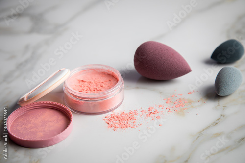 Looses Rouge Puder Make-up mit Blender Schwamm auf Marmor Beauty Schminktisch
