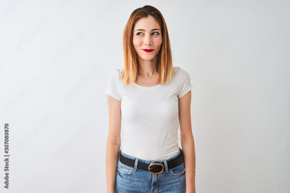 Obraz premium Beautiful redhead woman wearing casual t-shirt standing over isolated white background smiling looking to the side and staring away thinking.