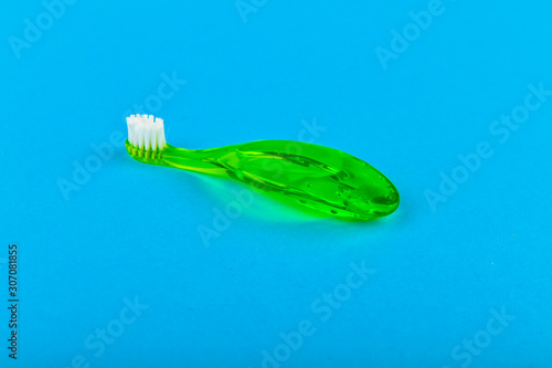 Green childrens toothbrush. on a blue background. Place for an inscription. Toothbrushing a child.