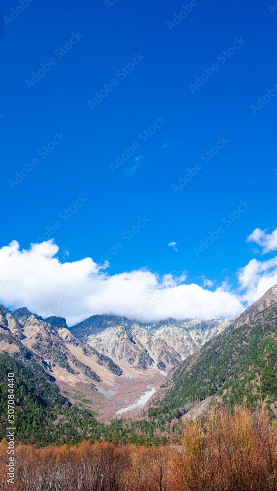 Beautiful landscape of nature snow mountain leaves change color in fall season and clear blue sky background at kamikochi national park , Japan.