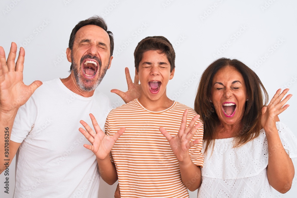 Family of three, mother, father and son standing over white isolated background celebrating mad and crazy for success with arms raised and closed eyes screaming excited. Winner concept Family of three, mother, father and son standing over white isolated background celebrating mad and crazy for success with arms raised and closed eyes screaming excited. Winner concept