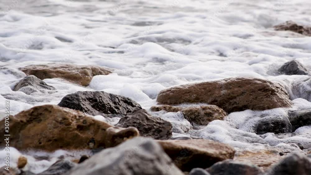 Closeup of a stony beach with sea waves Closeup of a stony beach with sea waves