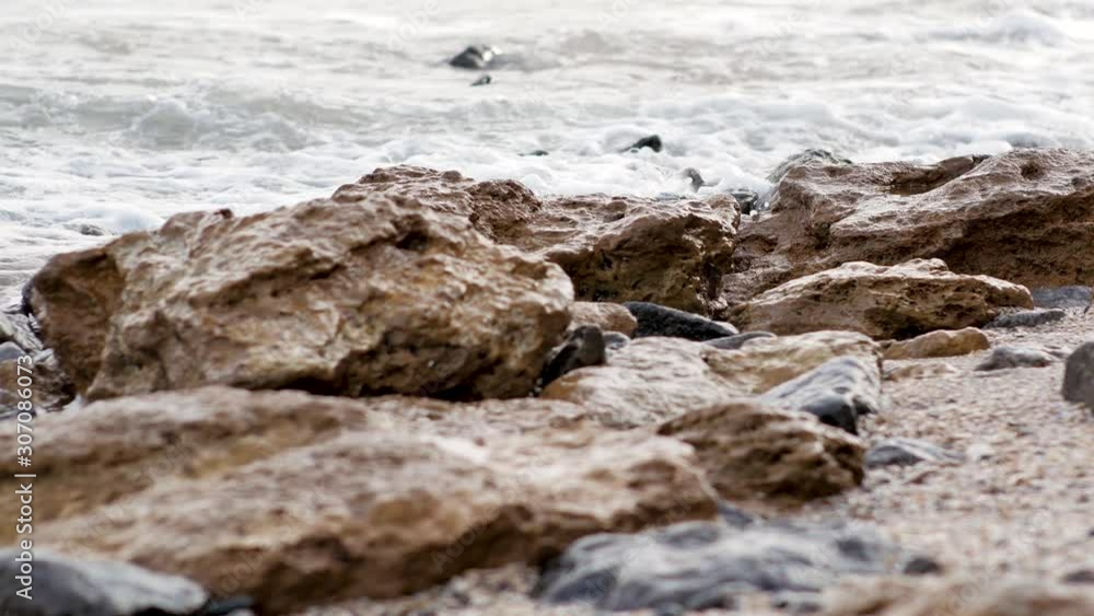 Closeup of a stony beach with sea waves Closeup of a stony beach with sea waves