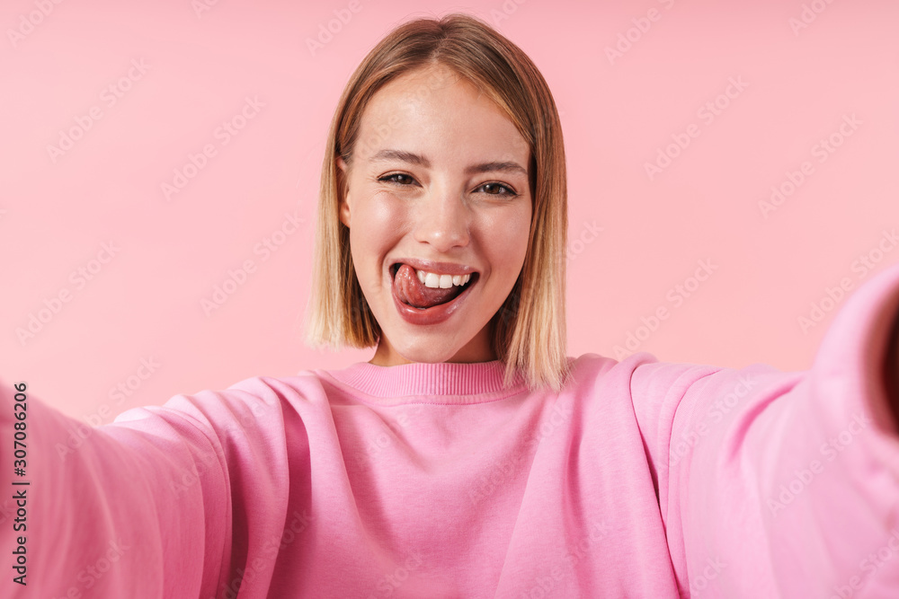 Portrait of happy woman smiling at camera while taking selfie photo Portrait of happy woman smiling at camera while taking selfie photo