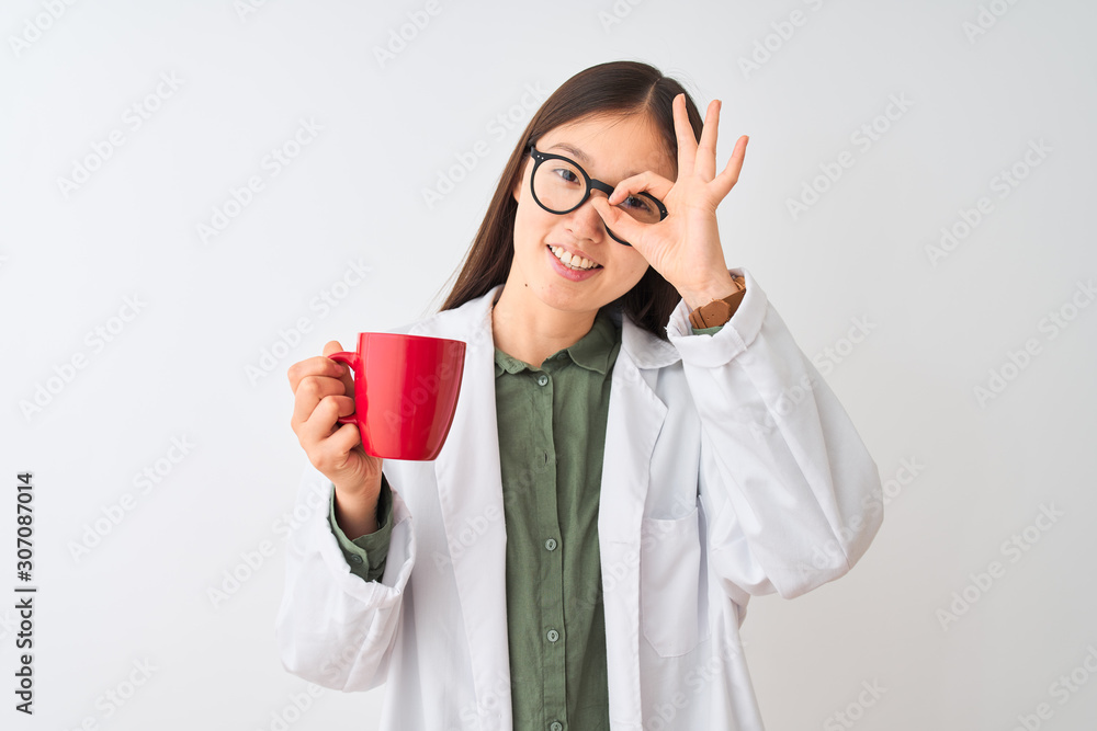 Young chinese dooctor woman wearing glasses drinking coffee over isolated white background with happy face smiling doing ok sign with hand on eye looking through fingers Young chinese dooctor woman wearing glasses drinking coffee over isolated white background with happy face smiling doing ok sign with hand on eye looking through fingers