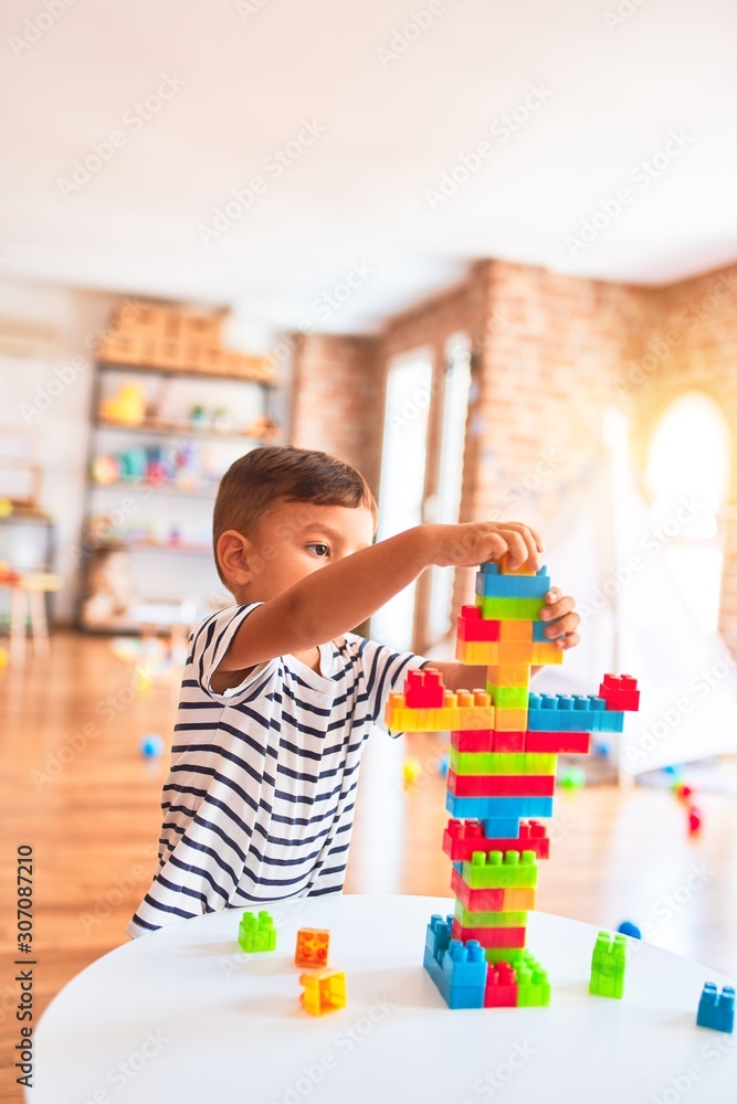 Beautiful toddler boy playing with construction blocks at kindergarten Beautiful toddler boy playing with construction blocks at kindergarten