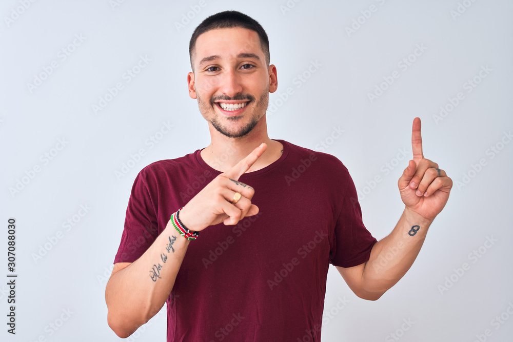 Young handsome man standing over isolated background smiling and looking at the camera pointing with two hands and fingers to the side. Young handsome man standing over isolated background smiling and looking at the camera pointing with two hands and fingers to the side.