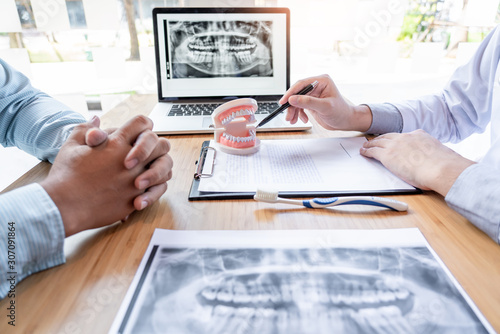 Medical team discussing, health care talking to female patient, Medical conferrence concept, doctor holding and looking at dental x-ray attending a client.