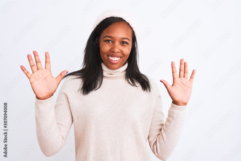 Beautiful young african american woman wearing turtleneck sweater and winter hat showing and pointing up with fingers number ten while smiling confident and happy. Beautiful young african american woman wearing turtleneck sweater and winter hat showing and pointing up with fingers number ten while smiling confident and happy.