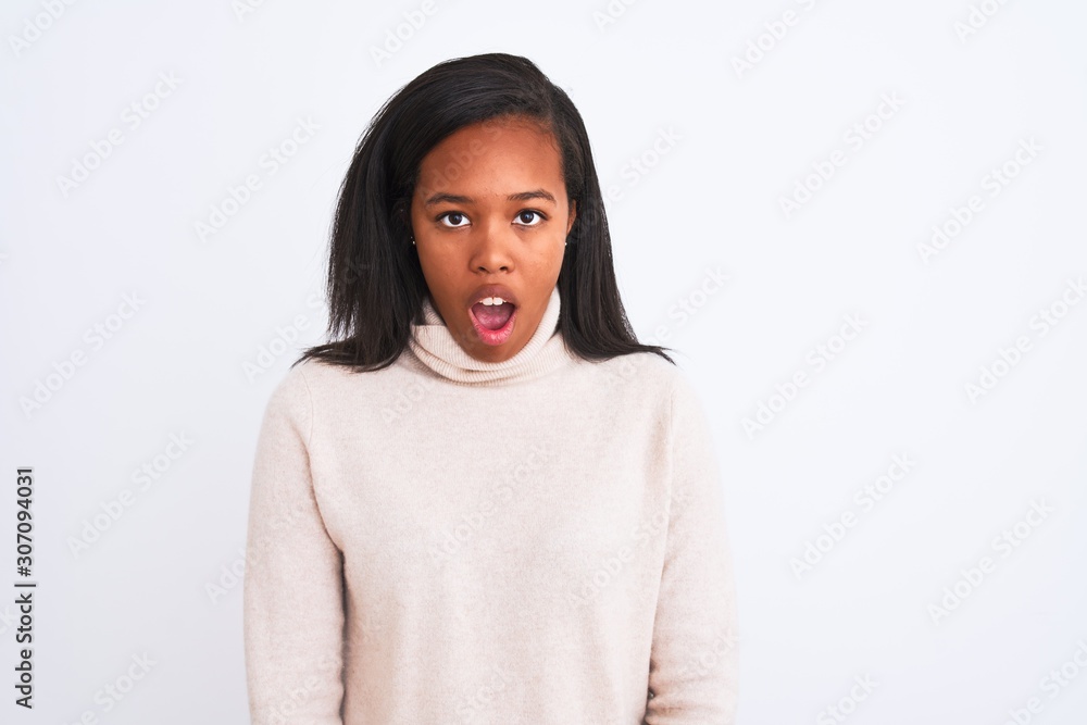Beautiful young african american woman wearing turtleneck sweater over isolated background afraid and shocked with surprise expression, fear and excited face. Beautiful young african american woman wearing turtleneck sweater over isolated background afraid and shocked with surprise expression, fear and excited face.