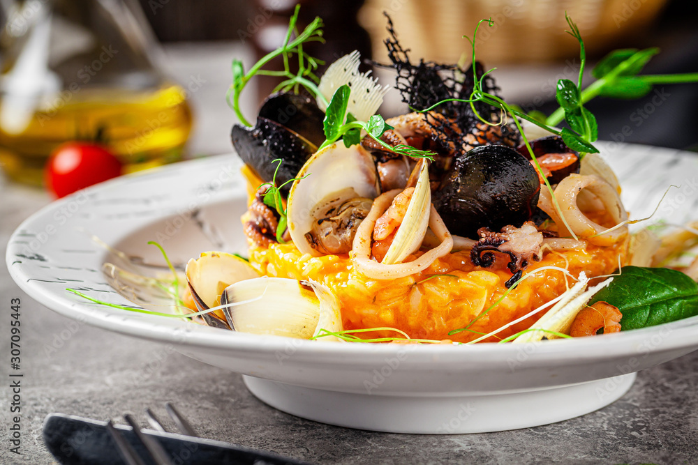 Italian food concept. Risotto with seafood, mussels, octopuses, squid. Serving dishes in a white plate. Modern serving in a restaurant. Background image. Copy space. - obrazy, fototapety, plakaty 