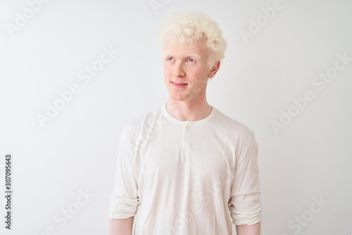 Young albino blond man wearing casual t-shirt standing over isolated white background smiling looking to the side and staring away thinking.